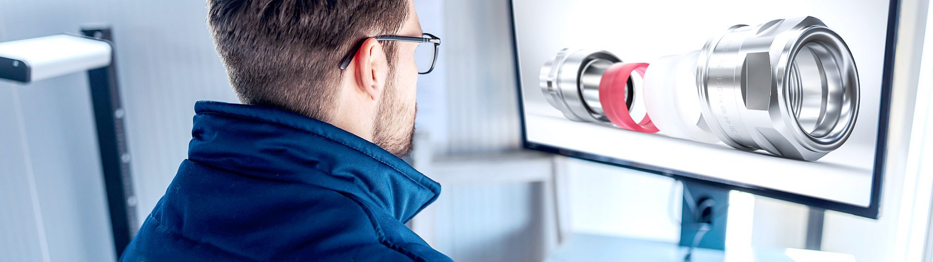 A man is looking at a screen and sees an exploded view of the LevelEx explosion-proof cable gland from PFLITSCH